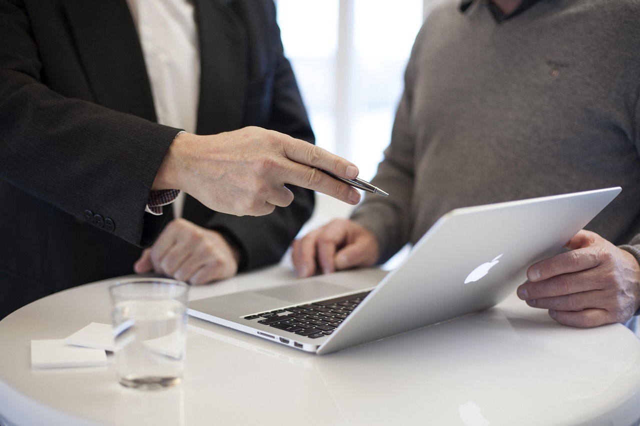 Two colleagues working through detail at a laptop