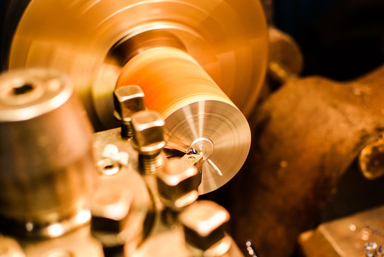 A metal component being turned on a lathe in a machine shop